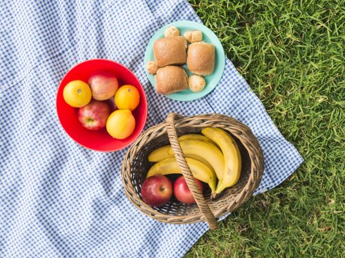 picnic-basket-with-fruits-bread-check-blanket-green-grass